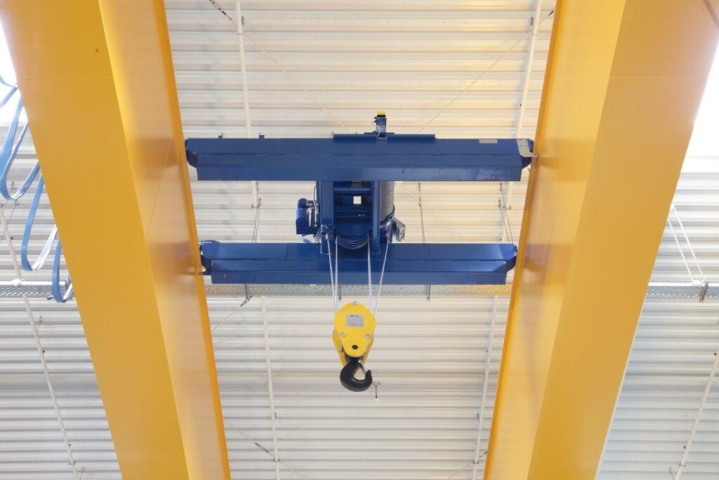 راهبر جرثقیل در حال جابه‌جایی بار در محیط صنعتی